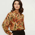 Chemisier femme fantaisie NO AGE Carol avec motif coloré, manches longues et col classique, porté avec un style décontracté.